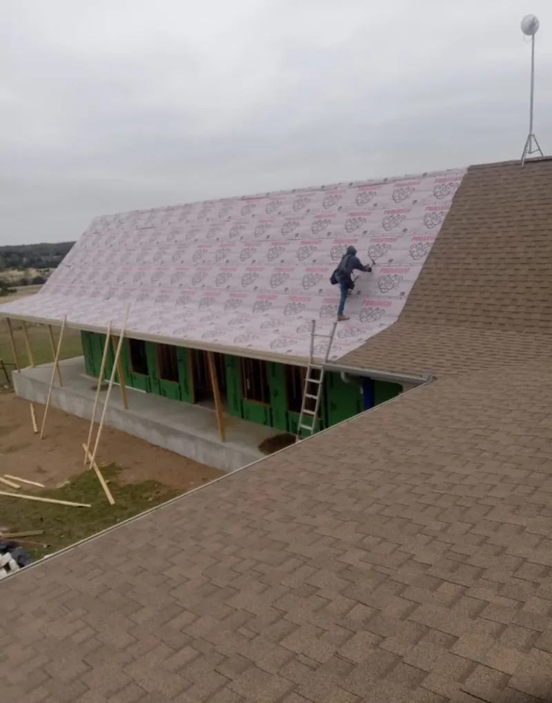 Worker preparing underlayment for a metal roof installation in Dock Junction